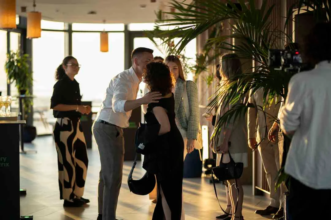 Guests arriving and talking in the warm light at Radio Rooftop
