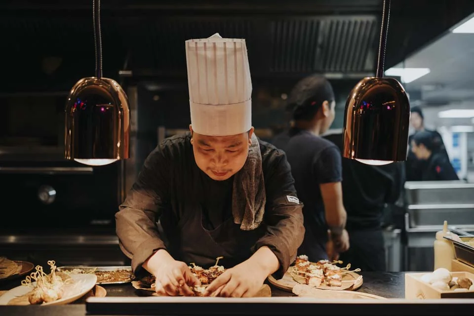 A chef preparing dishes · Mamachi, St Julian’s