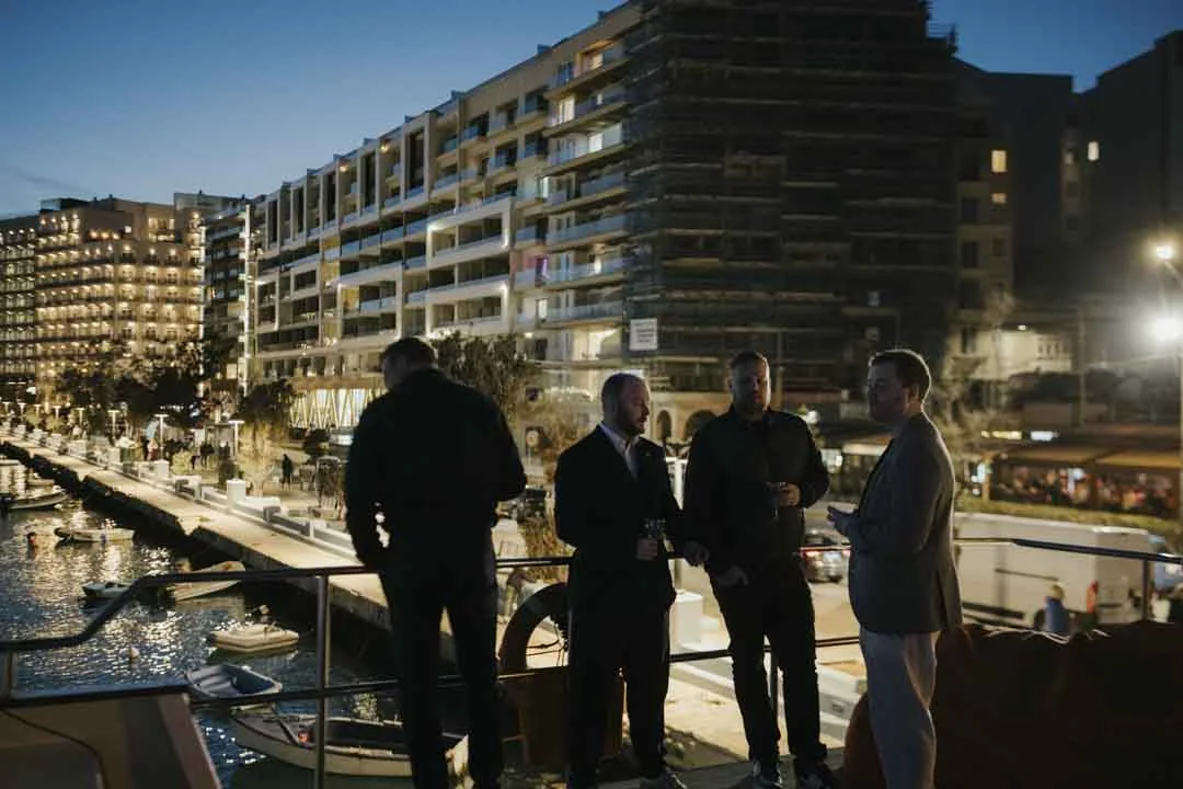 Guests on deck beside the city skyline · AFLOAT — Exclusive Networking at Sea
