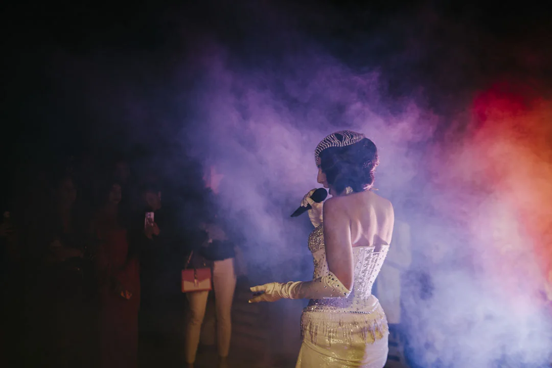 A performer beneath coloured stage lights · AFLOAT — Exclusive Networking at Sea