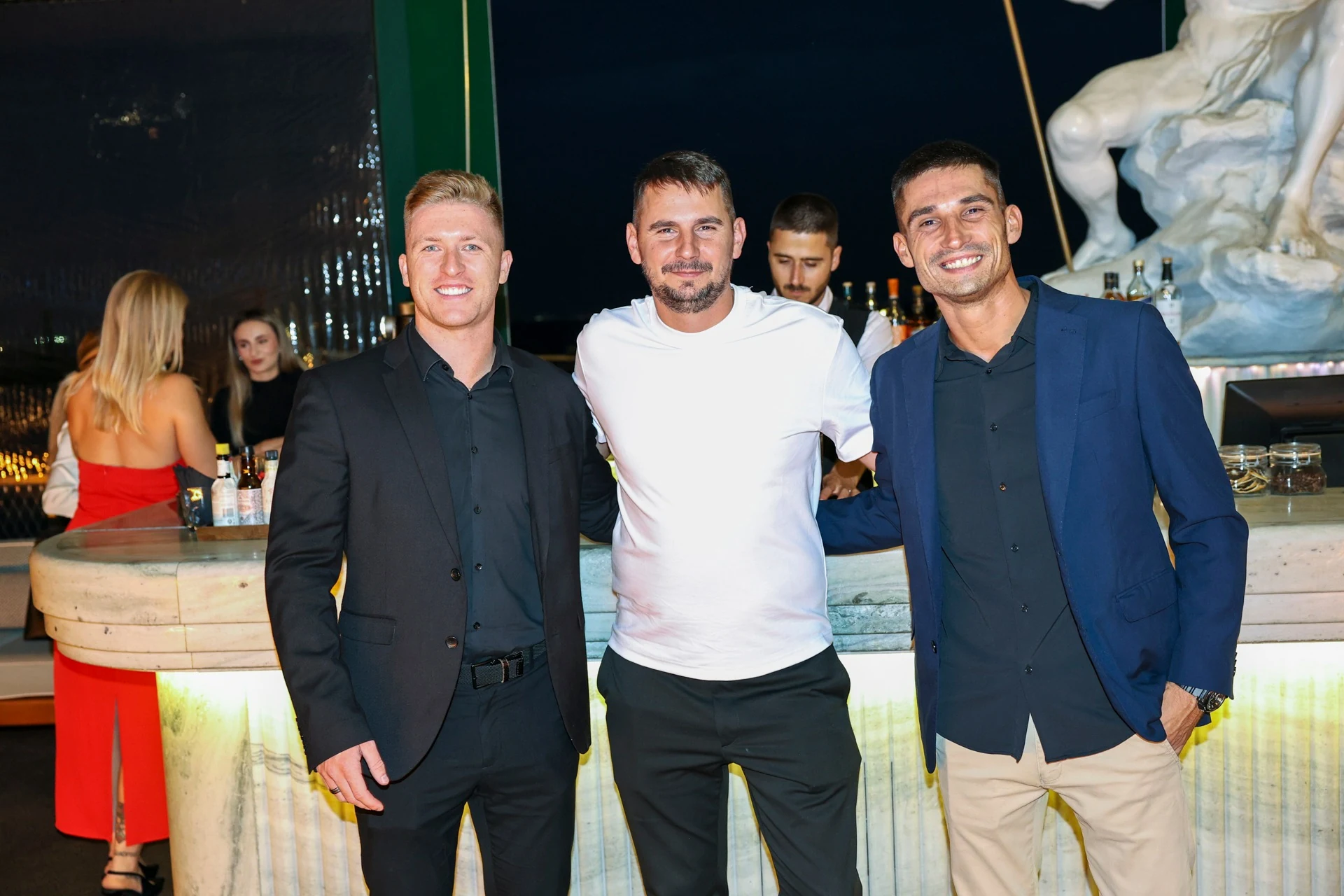 Three guests beside the bar at Altitude Lisbon 2026.